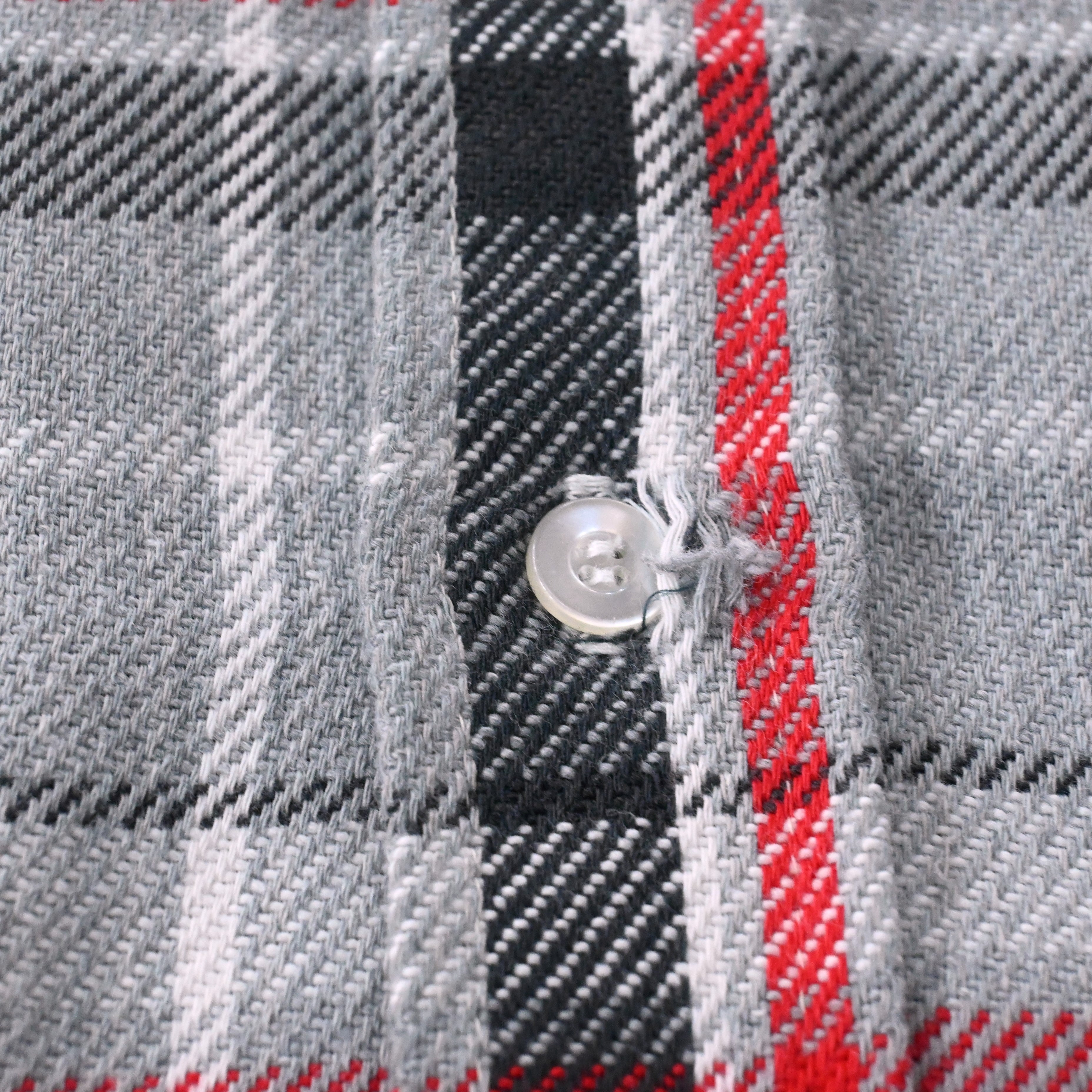 ボタンホールのホツレがございます。